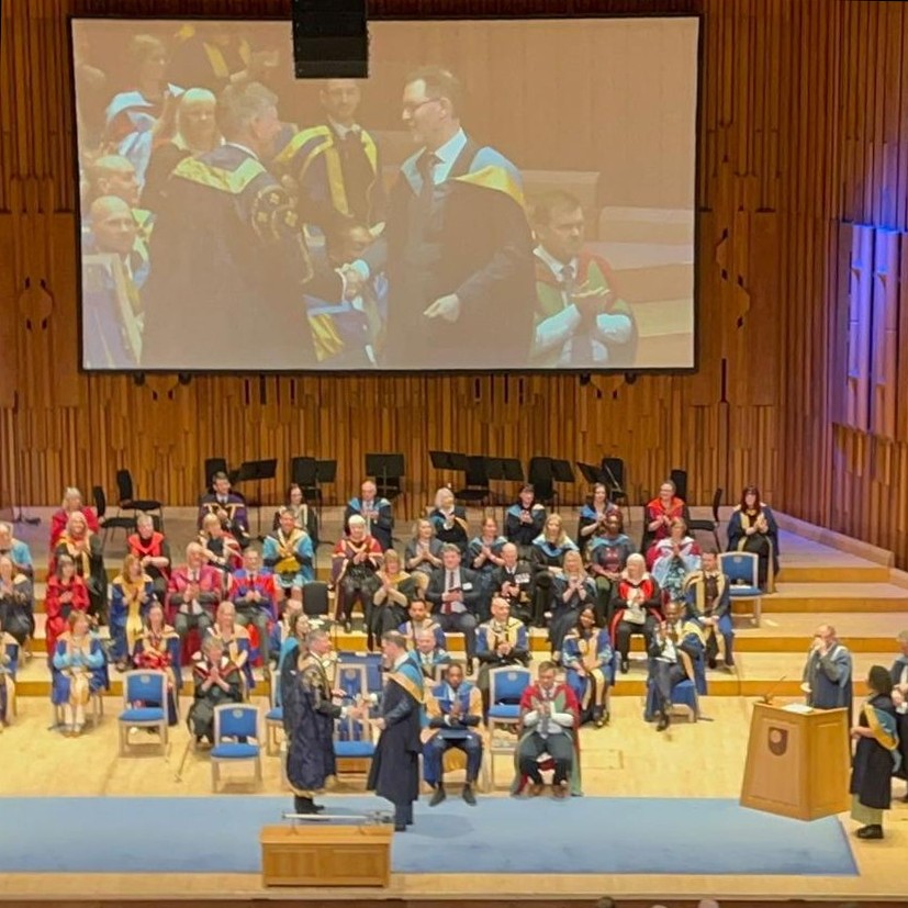 Me crossing the stage at the Barbican in London during the Open University graduation ceremony